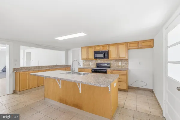 a kitchen with stainless steel appliances granite countertop a sink a stove a microwave a counter top space and cabinets