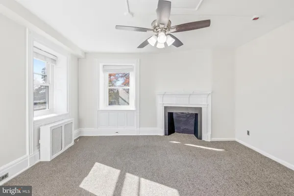 wooden floor fireplace and windows in an empty room