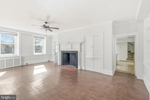 an empty room with windows and fireplace