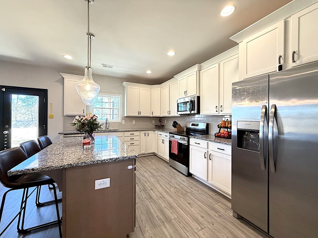 27 Sugar Maple Drive Fort Mitchell, AL 36856 - Photo 7 of 28 a kitchen with stainless steel appliances granite countertop a refrigerator a stove a sink dishwasher and a refrigerator with wooden floor