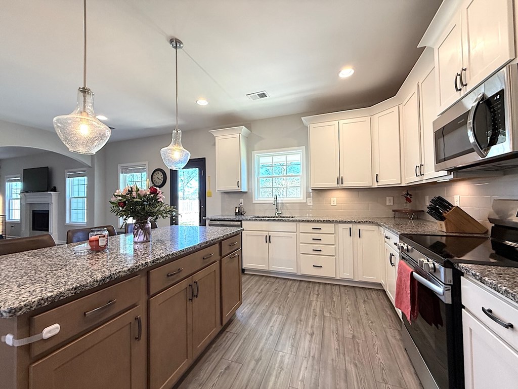 27 Sugar Maple Drive Fort Mitchell, AL 36856 - Photo 8 of 28 a kitchen with stainless steel appliances granite countertop wooden cabinets a stove a sink and a center island