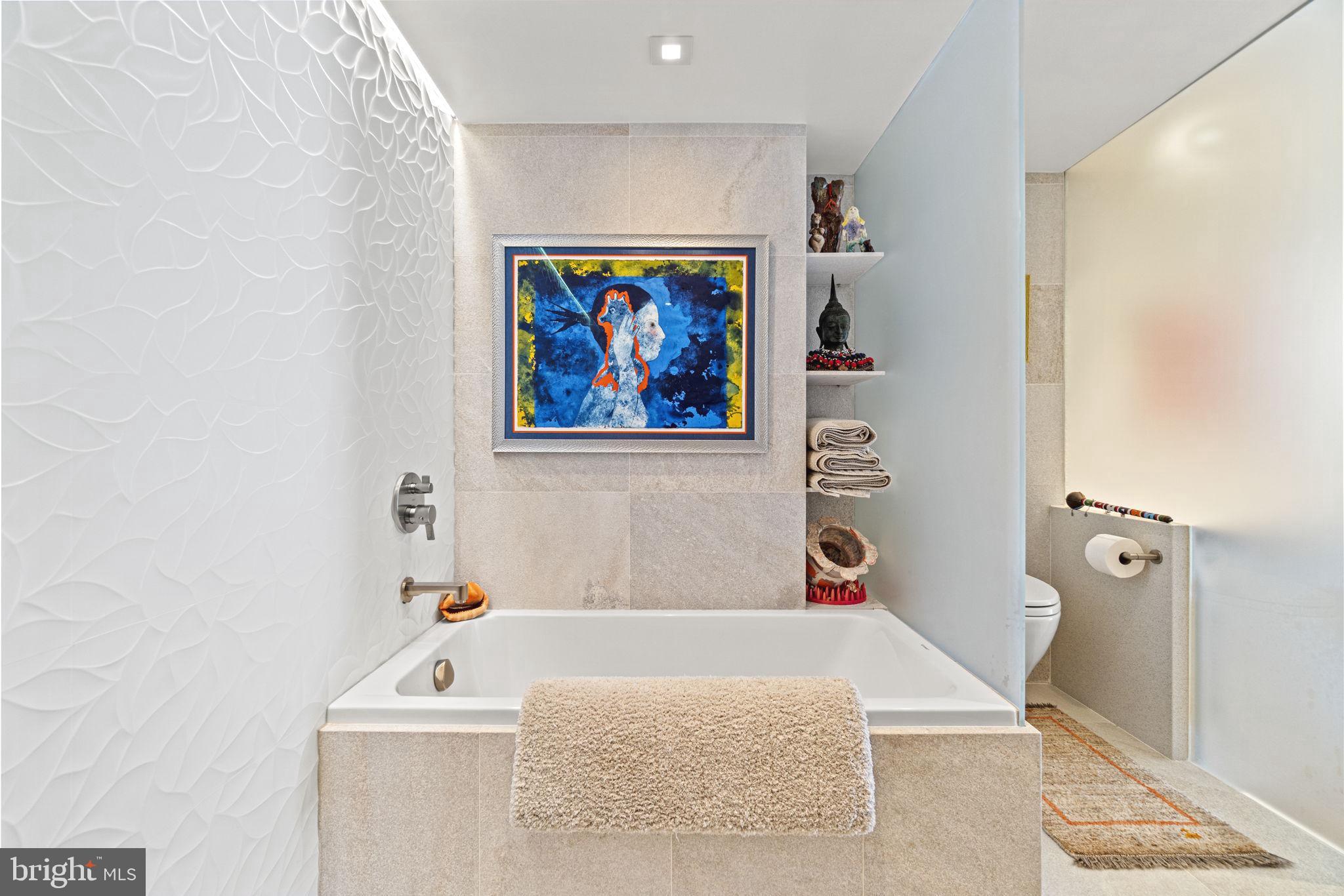 912 F Street Northwest, Unit 1100 Washington, DC 20004 - Photo 12 of 23 a bathroom with a tub a sink and a shower curtain