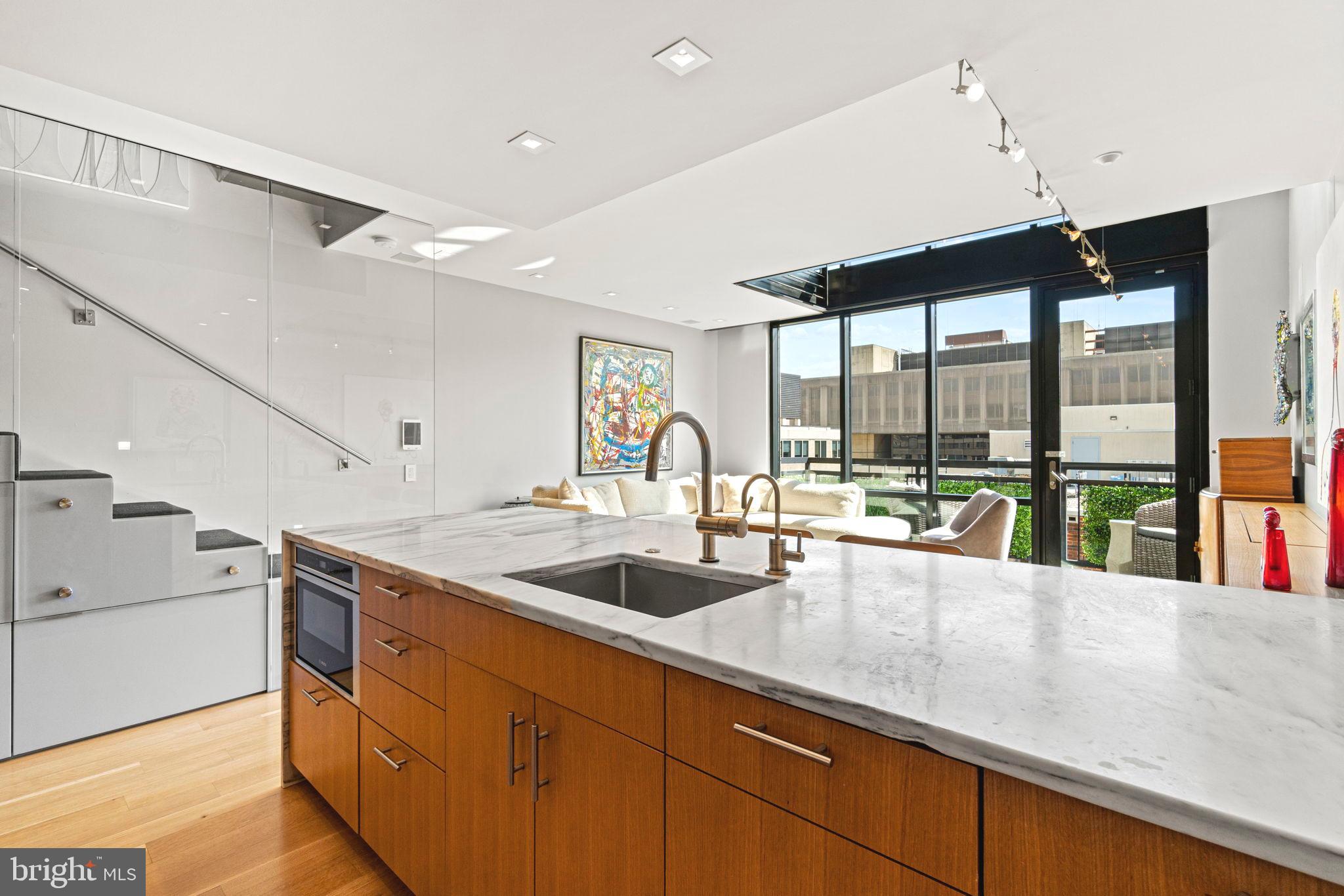 912 F Street Northwest, Unit 1100 Washington, DC 20004 - Photo 10 of 23 a kitchen with granite countertop a sink and a counter top space