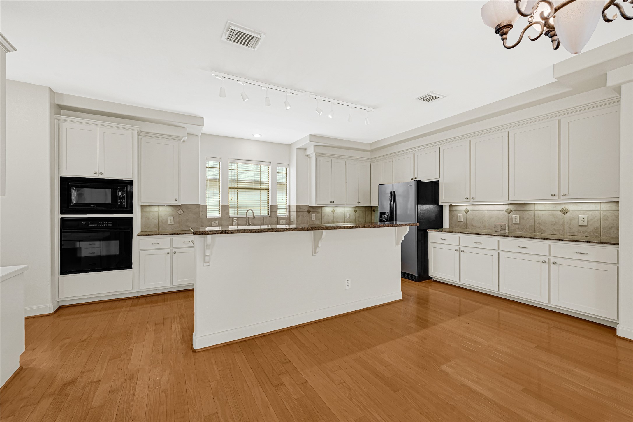 2414 Calumet Street, Unit B Houston, TX 77004 - Photo 11 of 27 a kitchen with stainless steel appliances granite countertop a stove a sink and white cabinets