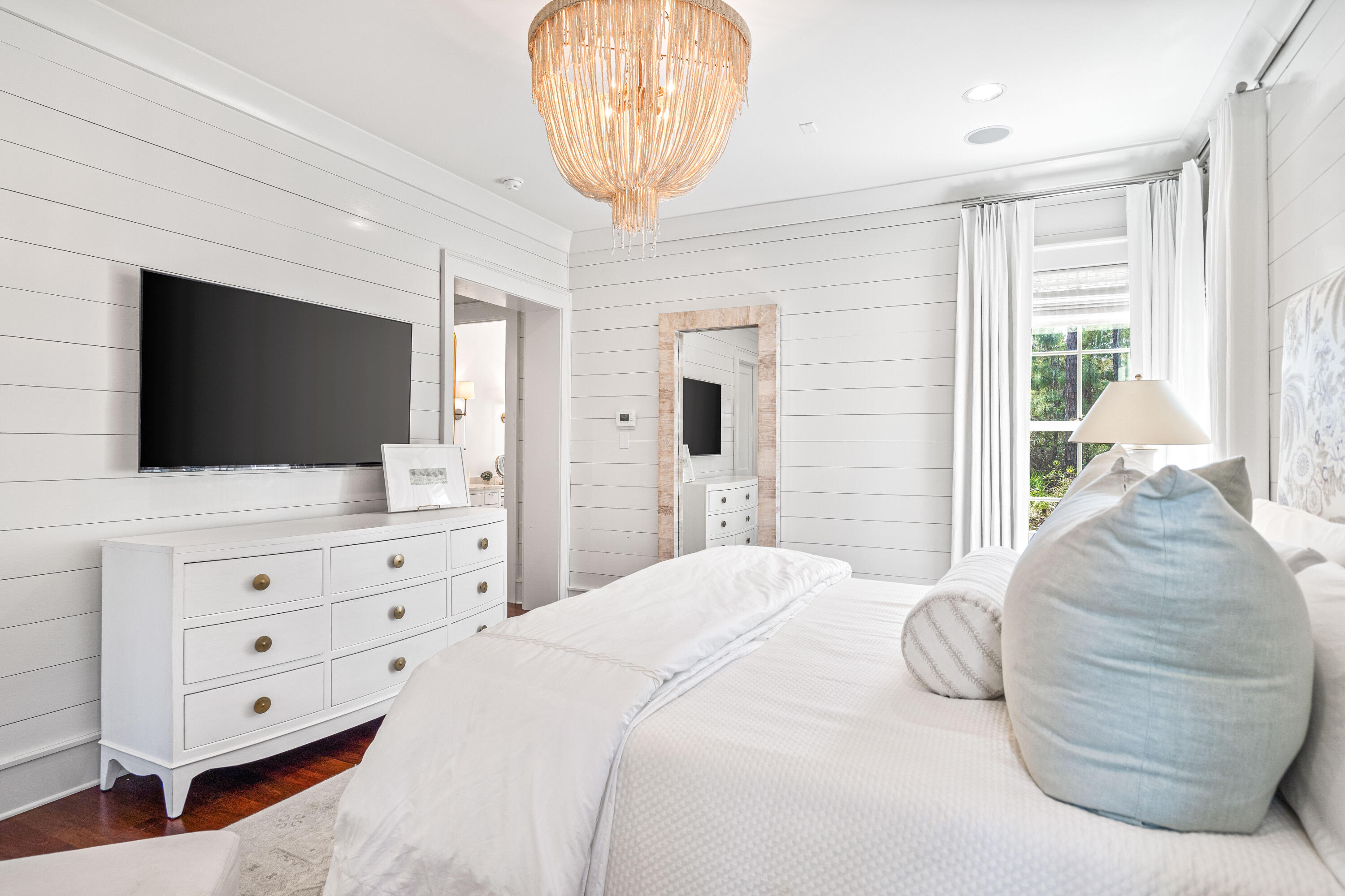 8 Shingle Lane Watersound, FL 32461 - Photo 19 of 73 a bedroom with a bed a mirror on dresser and a flat screen tv