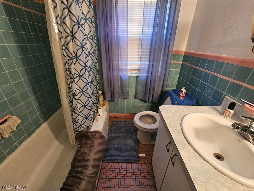 13513 Cedar Road Cleveland, OH 44118 - Photo 23 of 36 Full bathroom featuring shower / bathtub combination with curtain, tile walls, backsplash, toilet, and tile flooring