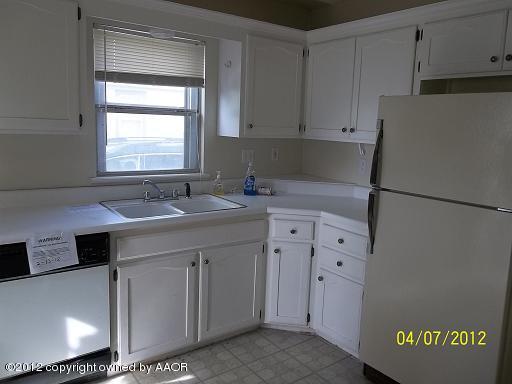 4008 South Hughes Street Amarillo, TX 79110 - Photo 3 of 7 a kitchen with cabinets appliances a sink and a window
