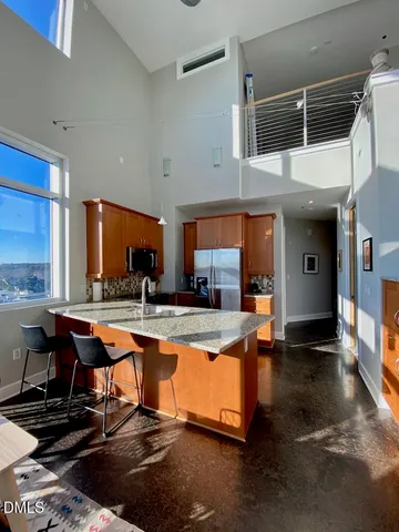 a view of a kitchen with kitchen island granite countertop a large window and a counter space