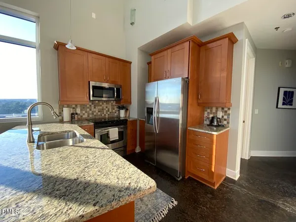 a kitchen with granite countertop a refrigerator and a sink
