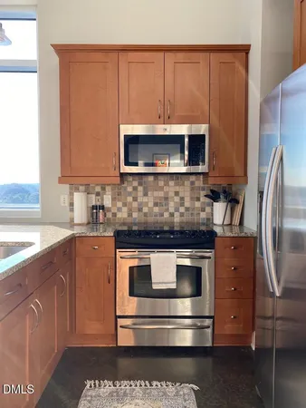 a kitchen with stainless steel appliances granite countertop a stove a microwave and a sink