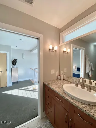 a bathroom with a granite countertop sink and a mirror