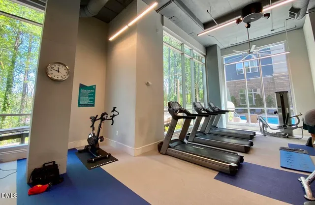 a living room with furniture gym equipment and a large window