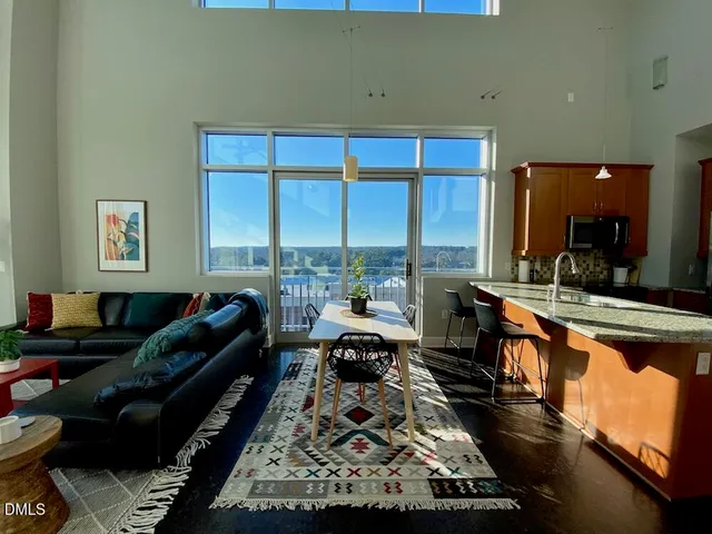 a living room with large window and a rug