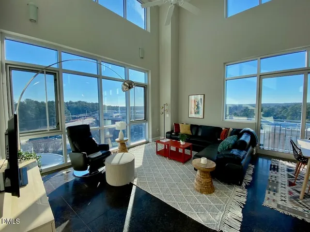 a living room with furniture and floor to ceiling windows