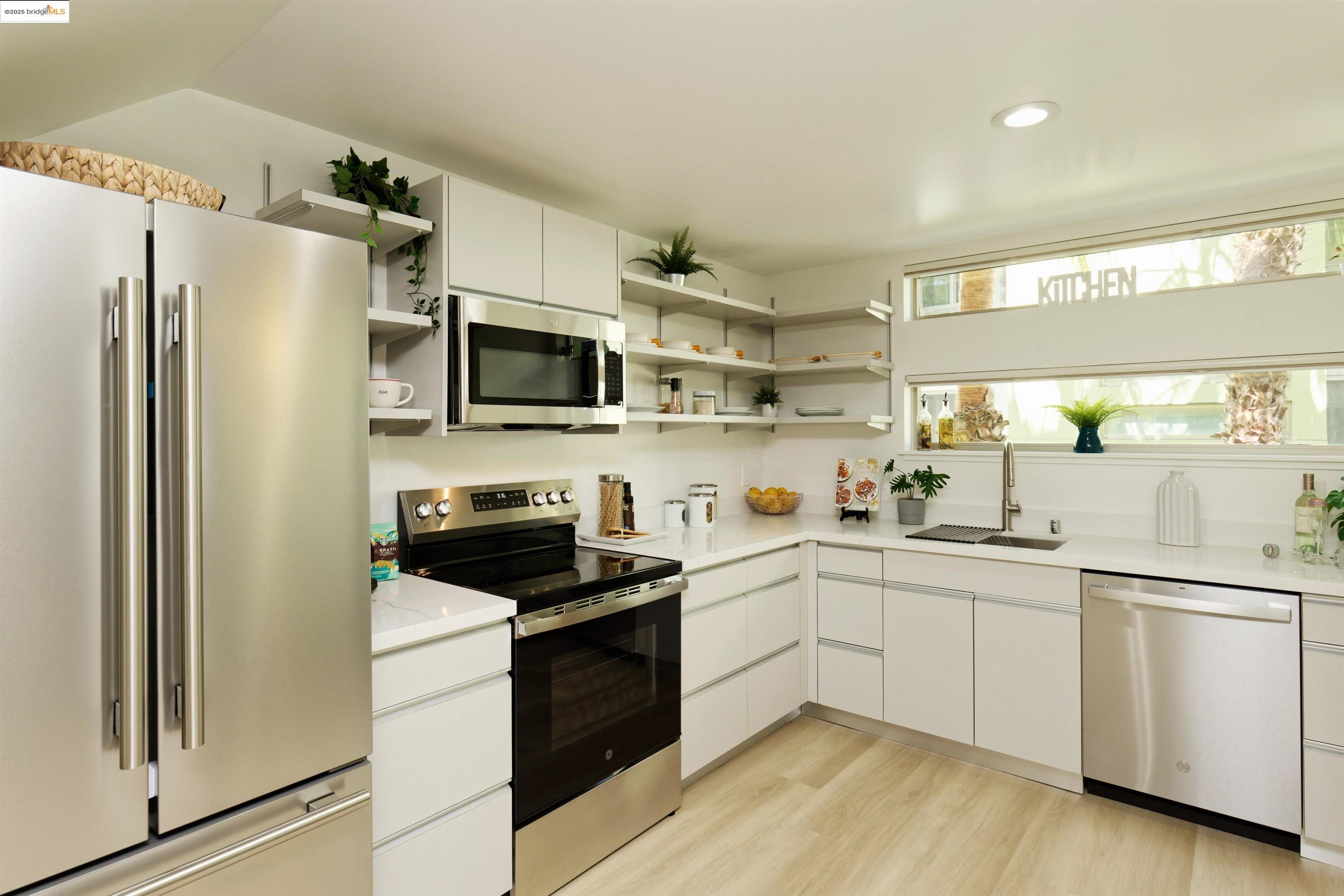 1201 Pine Street, Unit 315 Oakland, CA 94607 - Photo 12 of 41 Kitchen featuring stainless steel appliances, white cabinetry, light wood-style flooring, modern cabinets, and open shelves