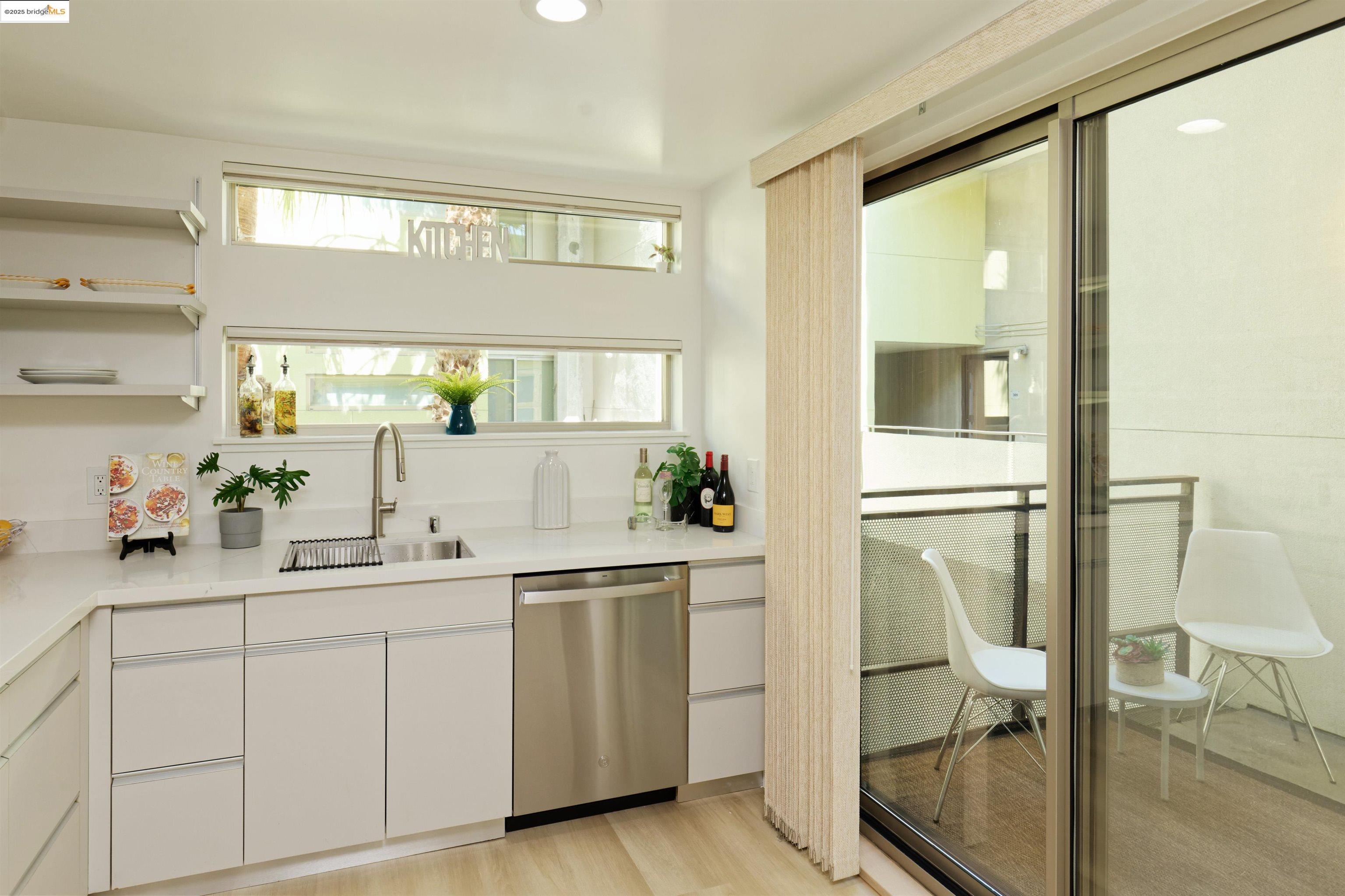 1201 Pine Street, Unit 315 Oakland, CA 94607 - Photo 13 of 41 Bar area with white cabinets, stainless steel dishwasher, light wood finished floors, recessed lighting, and modern cabinets