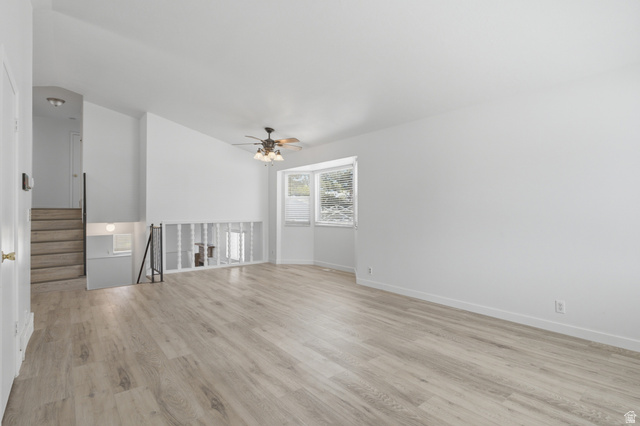 7910 Woolley Way Magna, UT 84044 - Photo 6 of 26 Spacious interior featuring light wood-finish flooring, white walls, and a ceiling fan with integrated lighting
