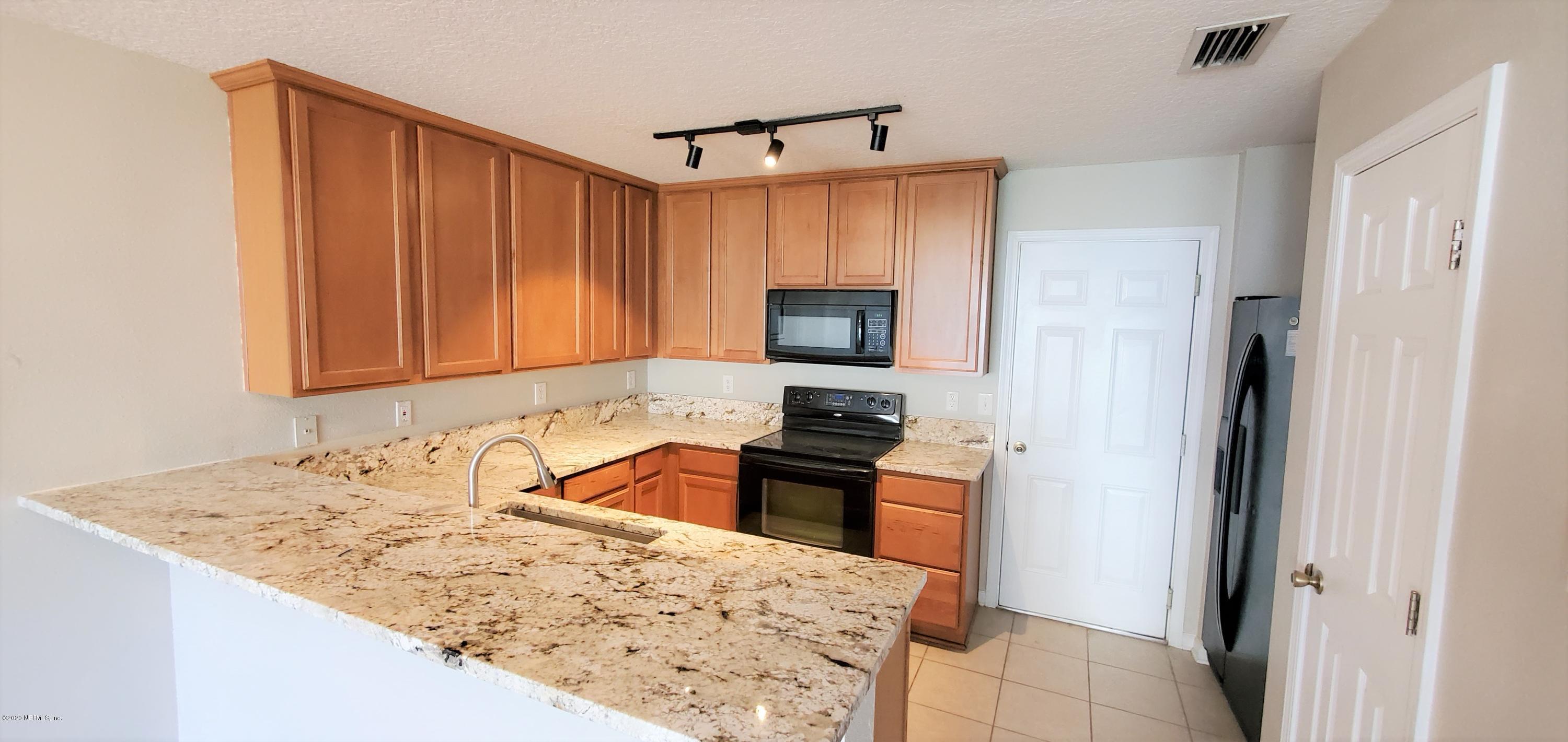 1500 Calming Water Drive, Unit 1003 Fleming Island, FL 32003 - Photo 2 of 13 a kitchen with a sink stove and refrigerator