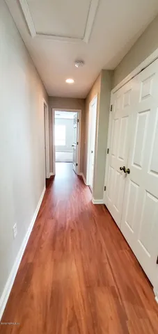 a view of a hallway with wooden floor