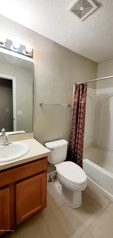 a bathroom with a sink a toilet a mirror and shower