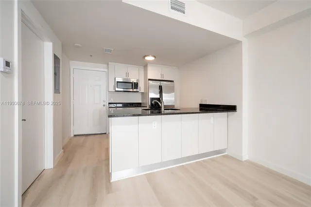 a view of kitchen with refrigerator sink and cabinets