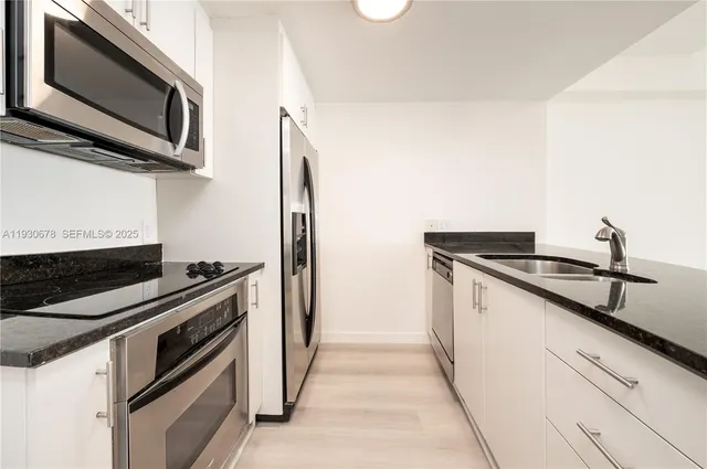 a kitchen with stainless steel appliances a stove microwave and sink