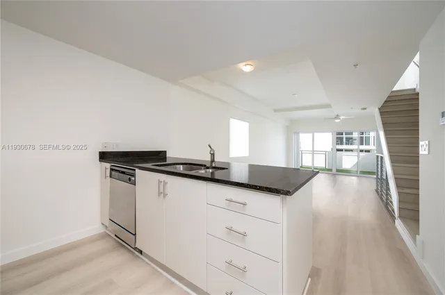 a kitchen with granite countertop cabinets a sink and a stove