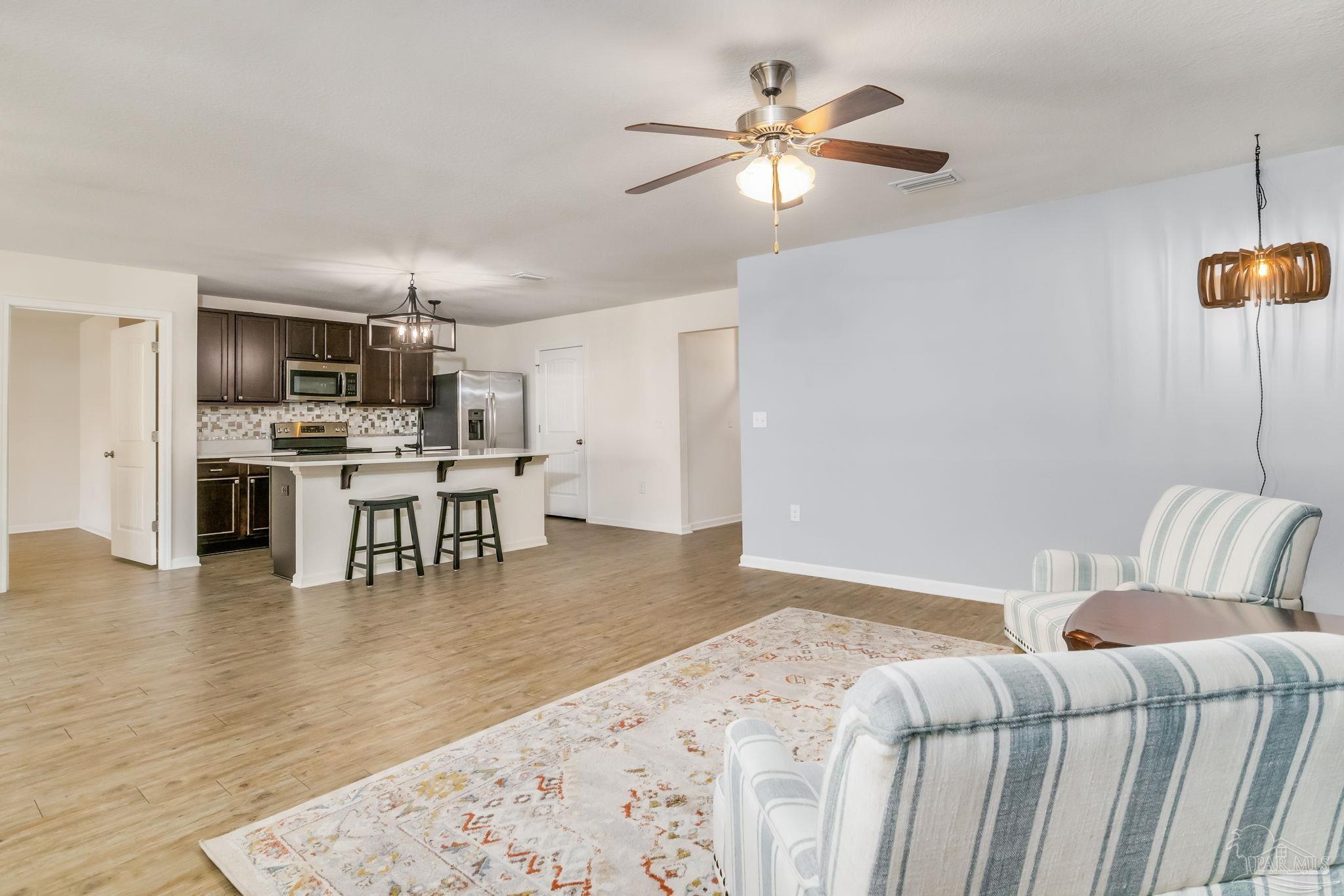4706 Apple Field Way Milton, FL 32571 - Photo 11 of 52 a living room with furniture and kitchen view