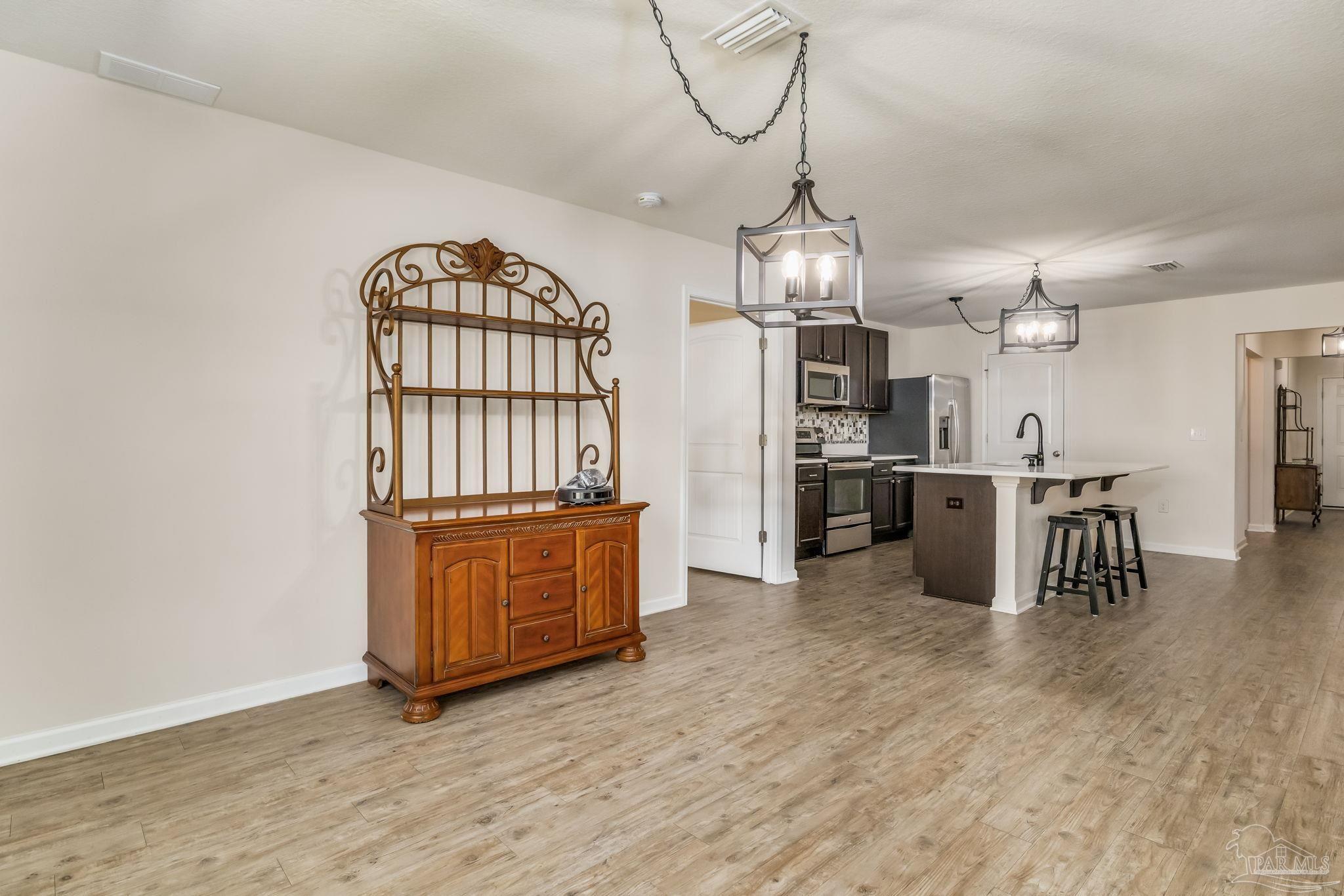 4706 Apple Field Way Milton, FL 32571 - Photo 13 of 52 a view of a kitchen with a sink wooden cabinets and stainless steel appliances