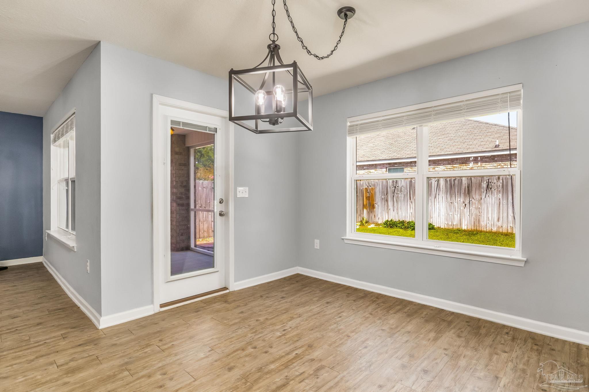 4706 Apple Field Way Milton, FL 32571 - Photo 15 of 52 en empty room with window and wooden floor