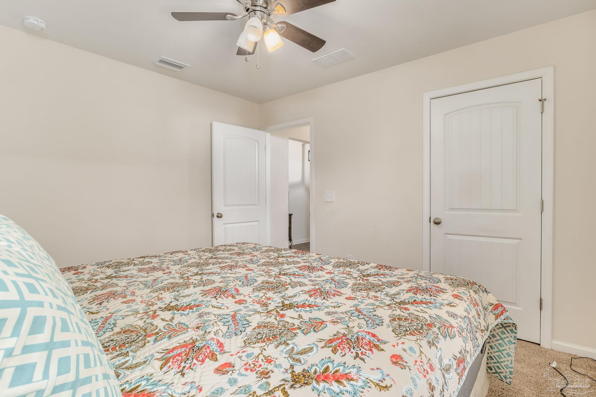 4706 Apple Field Way Milton, FL 32571 - Photo 29 of 52 a bedroom with a large bed and a chandelier