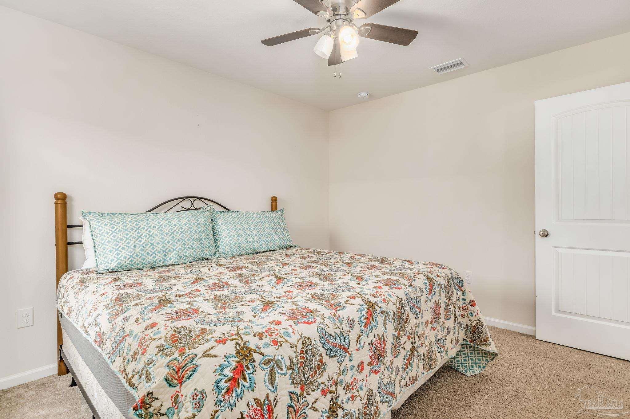 4706 Apple Field Way Milton, FL 32571 - Photo 31 of 52 a large bed sitting in a bedroom next to a window