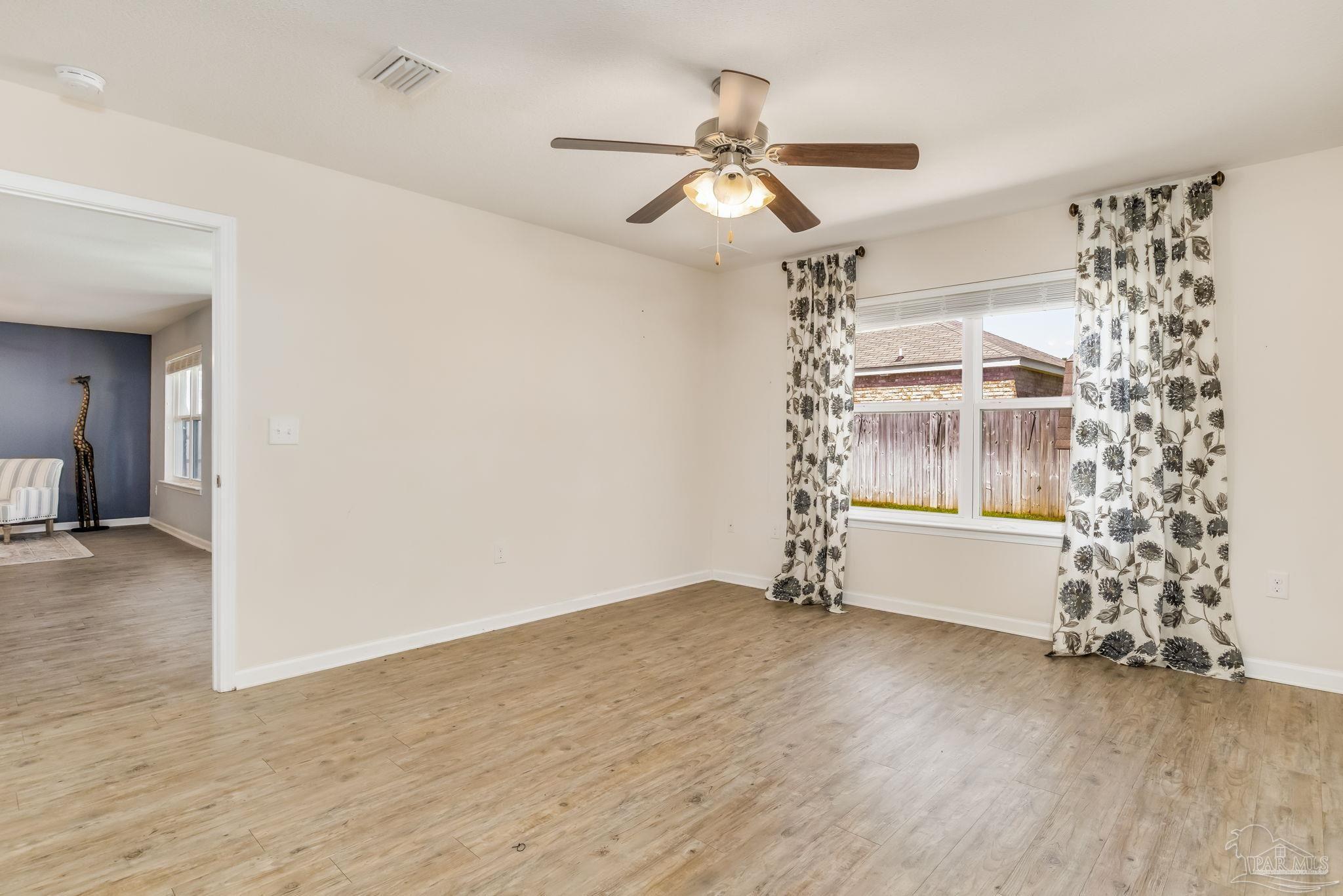 4706 Apple Field Way Milton, FL 32571 - Photo 41 of 52 a view of an empty room with a window and wooden floor