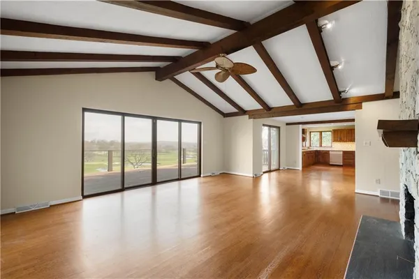 a view of empty room with wooden floor and fireplace