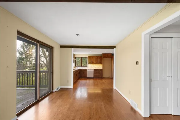 a kitchen with stainless steel appliances granite countertop a refrigerator a sink dishwasher and wooden cabinets with wooden floor