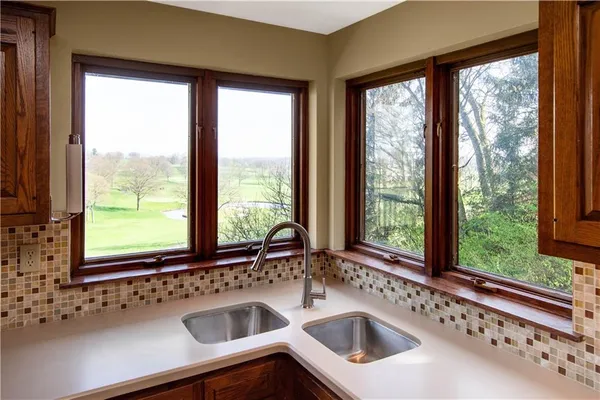 an empty room with wooden floor fireplace and windows