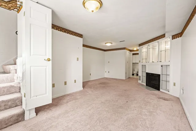 a view of empty room with a fireplace and window