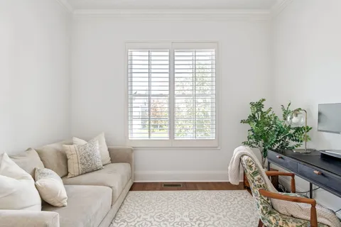 a living room with furniture kitchen view and a chandelier