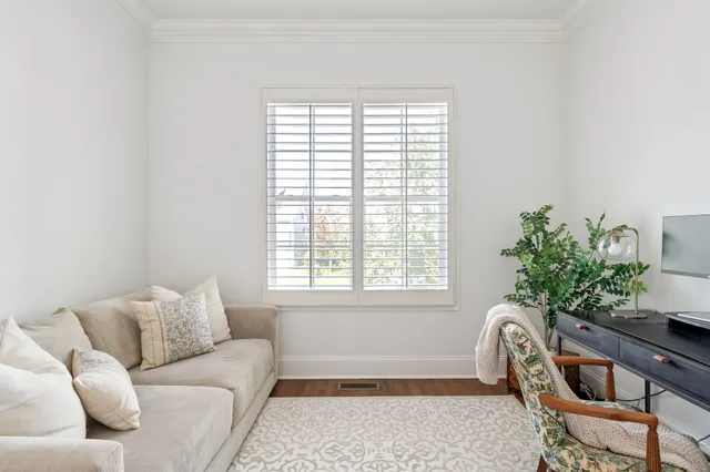 a living room with furniture kitchen view and a chandelier