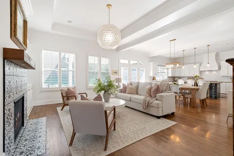 a kitchen with stainless steel appliances kitchen island granite countertop a table chairs and a view of living room
