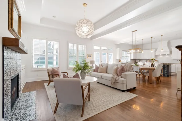 a kitchen with stainless steel appliances kitchen island granite countertop a table chairs and a view of living room
