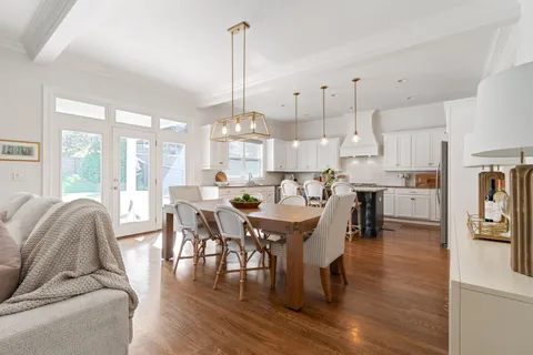 a bedroom with a bed a chandelier and a television