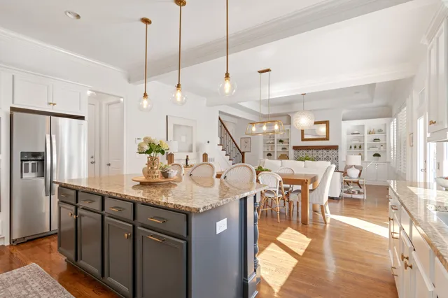 a bed sitting in a bedroom next to a window and a chandelier