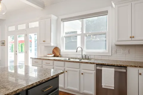 a bathroom with a granite countertop sink and a mirror