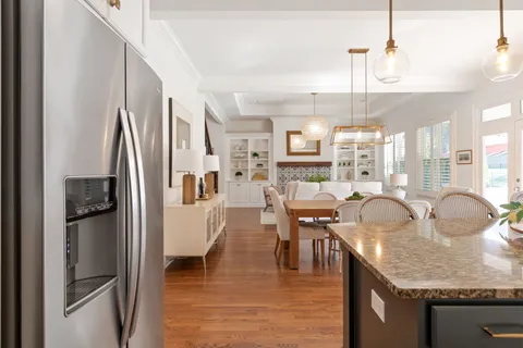 a view of a backyard with couches plants and large trees