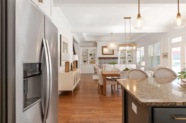 a view of a backyard with couches plants and large trees
