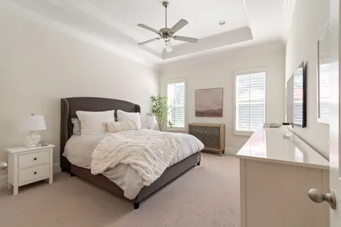 a view of a patio with couches and table under an umbrella with a garden