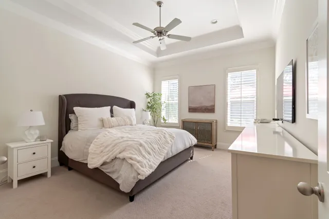 a view of a patio with couches and table under an umbrella with a garden