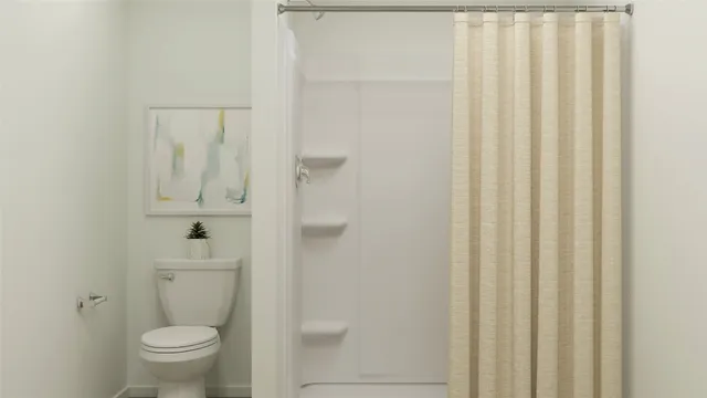 a bathroom with a toilet and a shower