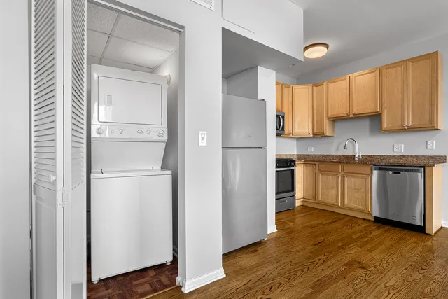 a kitchen with a white cabinets and wooden floor